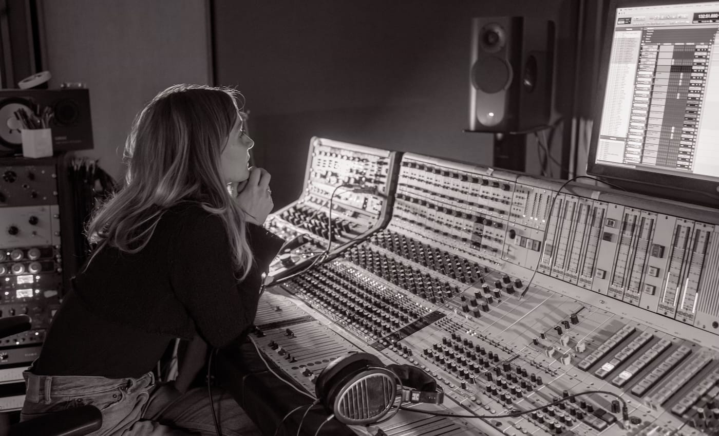 Hildur Guðnadóttir listening at a studio mixing console